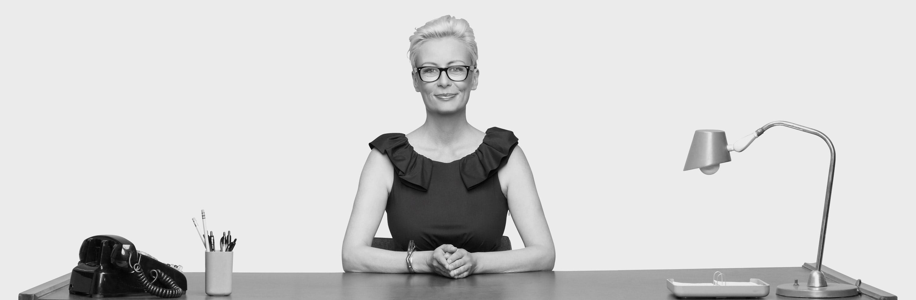 Happy female employer sitting a desk.